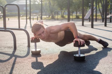 Genç kaslı erkek atlet push-up egzersizleri yapıyor