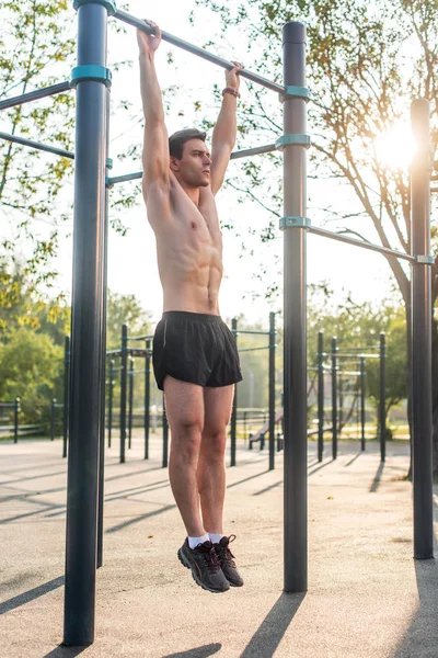 Ung muskulös atlet gör pull-up övningar — Stockfoto