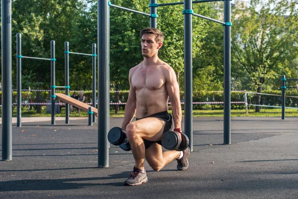 Modelo masculino fazendo exercícios dumbbell lunge — Fotografia de Stock