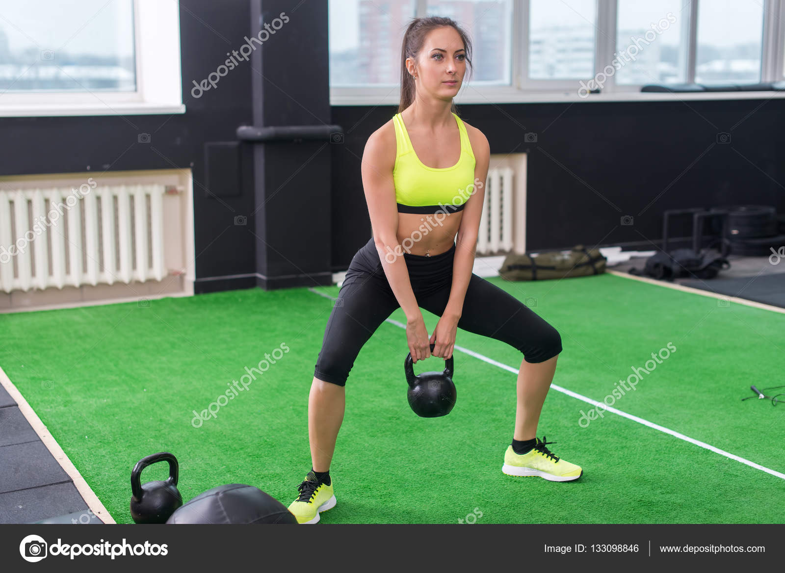 Athlete woman doing exercises lifting kettlebell Stock Photo by ©undrey  133098846