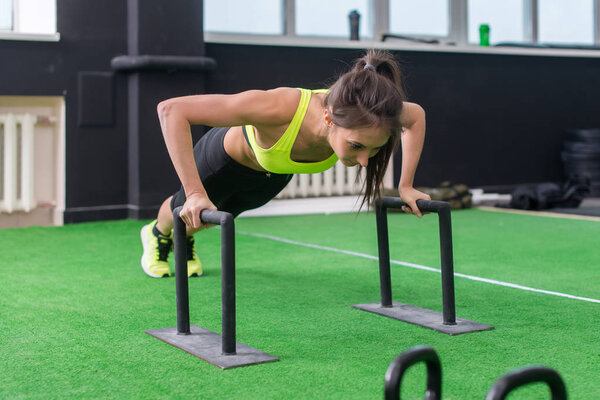 young fit woman doing horizontal push-ups