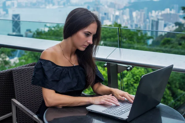 Junge attraktive Frau tippt oder arbeitet am Laptop — Stockfoto