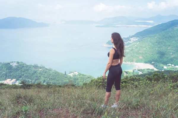 Jeune femme sportive debout sur la colline — Photo