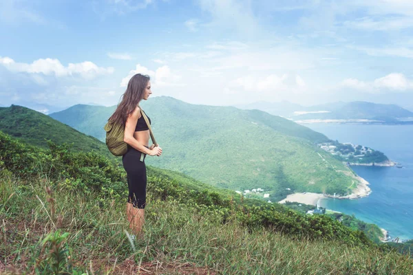Vrouwelijke reiziger rugzak permanent op heuvel — Stockfoto