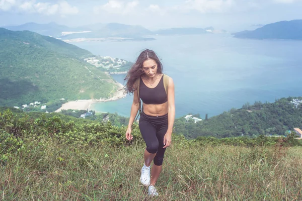 Müdes, fittes Mädchen geht den Berg hinauf — Stockfoto