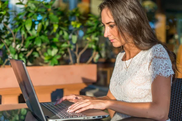 Seitenansicht einer jungen Schriftstellerin, die auf ihrem Laptop schreibt — Stockfoto