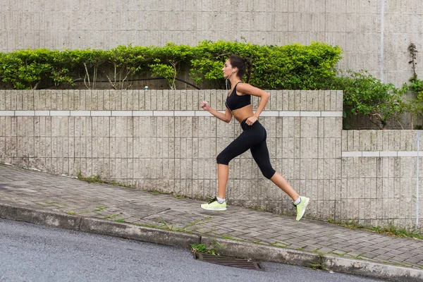 Mujer joven delgada corriendo cuesta arriba —  Fotos de Stock