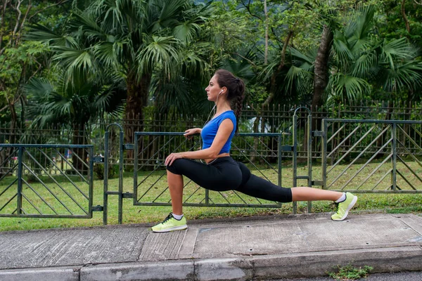 Idrottskvinna stretching i ben utfall position — Stockfoto