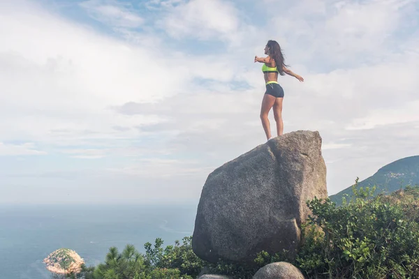 后视图的启发女运动员站在岩石上 — 图库照片