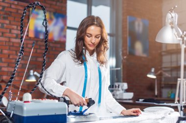 Çok kadın terzi kumaş parçalarını Ütü