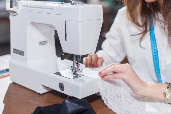 Female tailor stitching fine lace with sewing machine — Stock Photo, Image