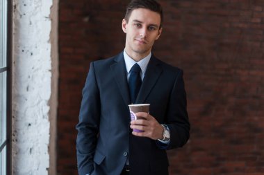 İşadamı ofiste kahve içiyor.