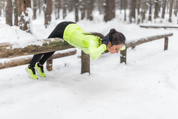 Fit femme faisant l'exercice d'extension de dos à l'extérieur dans les bois — Photo