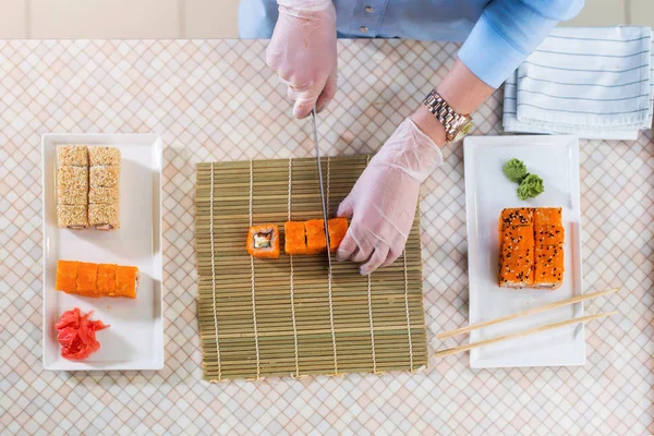 Female chef making sushi rolls — Stock Photo, Image