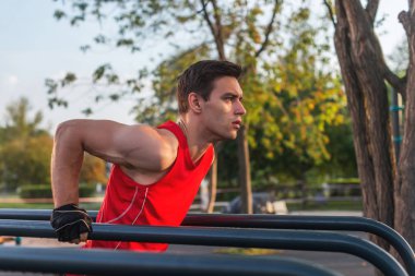 Uygun adam egzersiz dips yatay çubuklar üzerinde silah dışarı