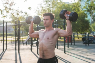 Kaslı erkek atlet kaldırma egzersizleri yapıyor
