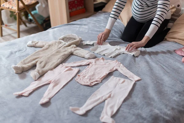 婴儿的衣服摆在床上 — 图库照片