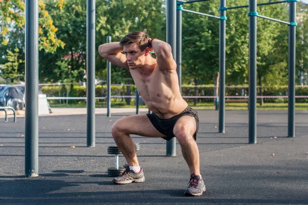 Gespierde fitness atleet doen squats — Stockfoto