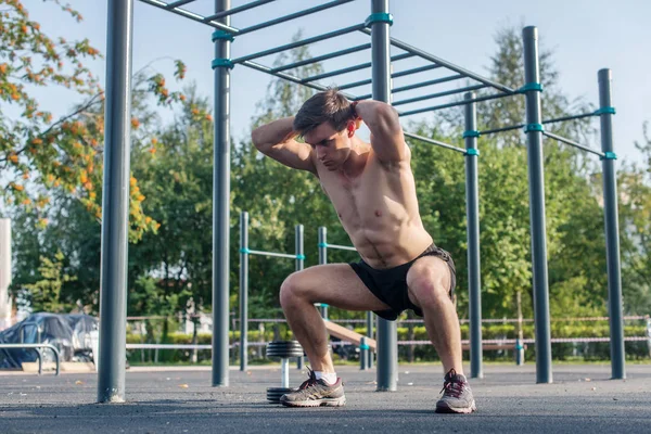 Gespierde fitness atleet doen squats — Stockfoto