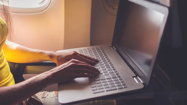 Женщина с помощью ноутбука в самолете — стоковое фото