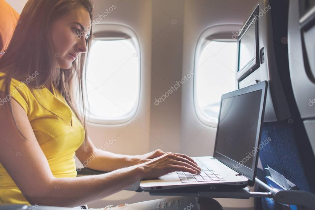 Woman using laptop in plane