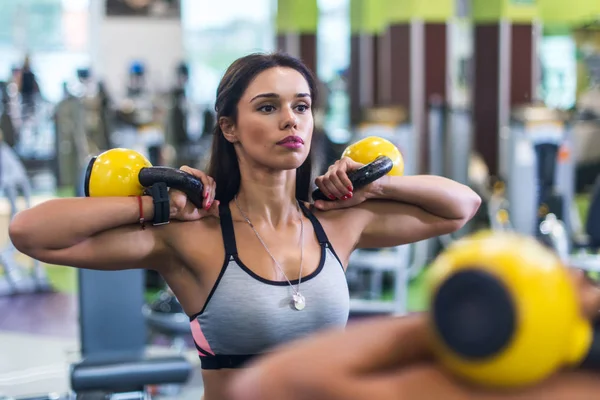 Spor salonunda kettlebell ile egzersiz yapan zinde bir kadın. — Stok fotoğraf