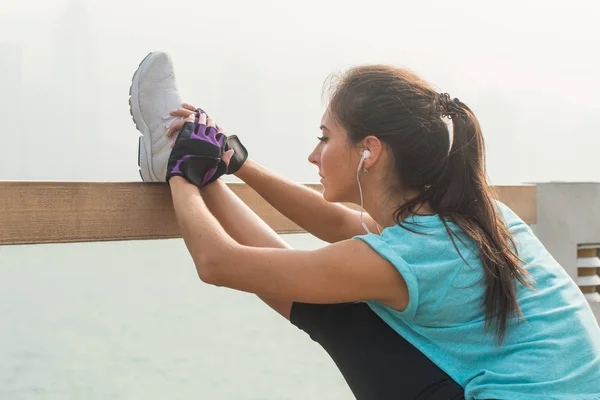 Junge Fitness-Frau streckt ihre Beine — Stockfoto