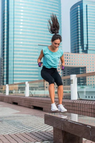 Actieve vrouw springen op benc — Stockfoto