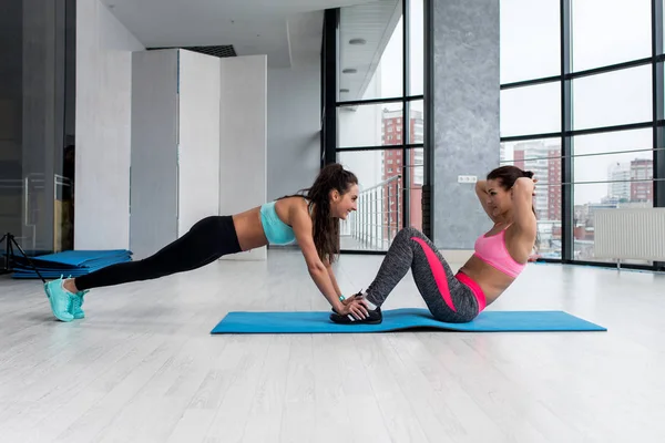 Two sportswomen doing pair exercise — Stock Photo, Image