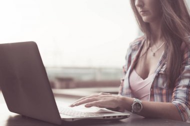 Dizüstü bilgisayarda yazı yazan kadın elleri.