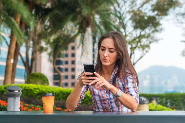 Молодая женщина использует свой мобильный телефон — стоковое фото