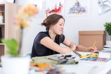 Genç kadın sanatçı ile Studio onun işyerinde kalem eskiz defteri kullanarak kroki çizim. Yan görünüm portre ilham ressam.