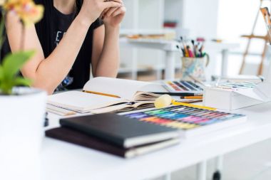 Yakın çekim Taslak çizim kalem kullanarak sketchbook bir kadın ressam görüş açısı. Sanatçı boya kalemi seti ile Sanat Atölyesi çizimi.
