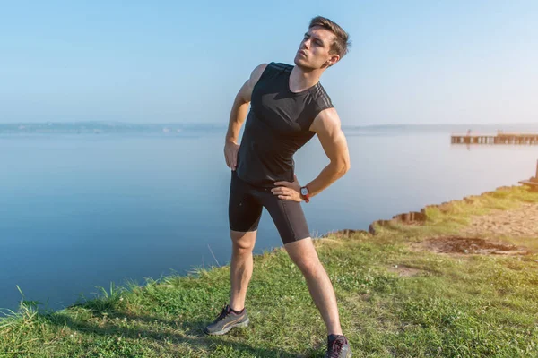 Fit mens stretching, training op frisse lucht uit te oefenen. — Stockfoto