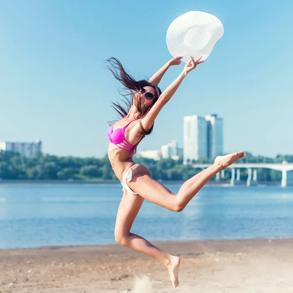 Hermosa mujer joven saltando en la playa . — Foto de Stock