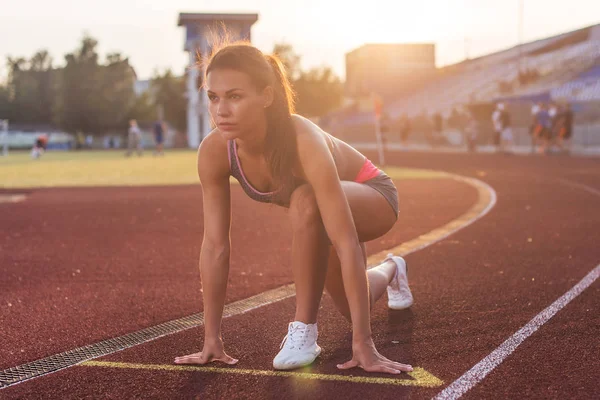 Adatta alla donna in posizione di partenza pronta per la corsa . — Foto Stock