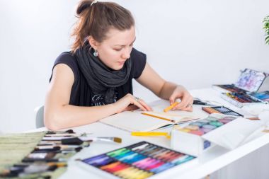 Genç kadın sanatçı ile Studio onun işyerinde kalem eskiz defteri kullanarak kroki çizim. Yan görünüm portre ilham ressam.
