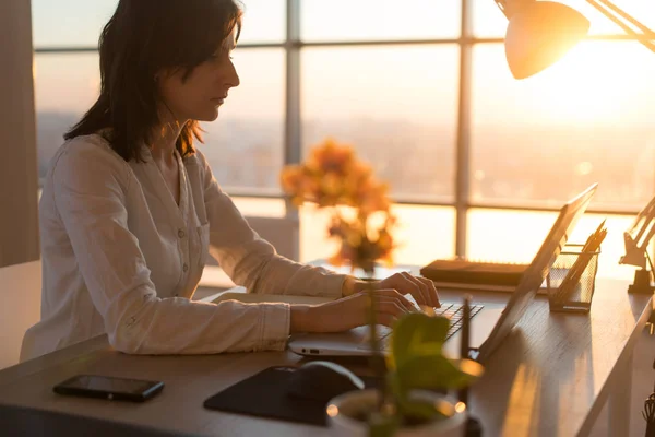 Koncentrerad kvinnliga medarbetare att skriva på arbetsplatsen med hjälp av dator. Sidan Visa porträtt av en copywriter arbetar på pc hemma. — Stockfoto