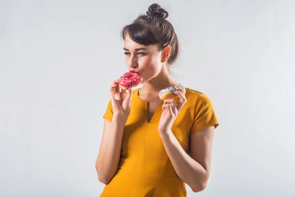 Junge lustige Brünette Modell mit Donuts posiert Studio Schuss auf weißem Hintergrund, nicht isoliert — Stockfoto