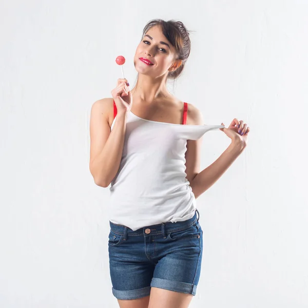 Jovem modelo morena com pirulito posando estúdio filmado em fundo branco, não isolado — Fotografia de Stock