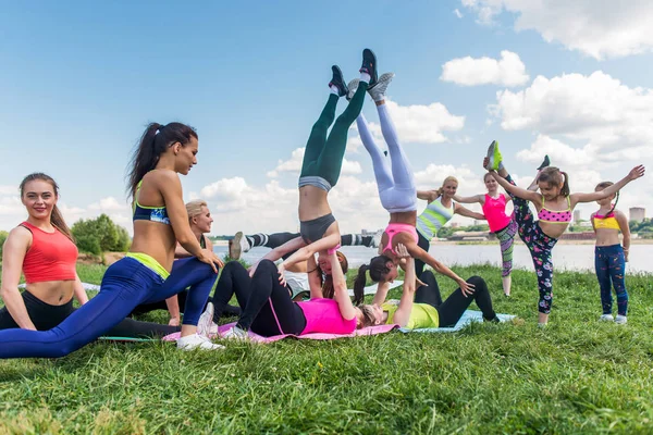 Grupp av passa kvinnor gör akrobatik trick utomhus — Stockfoto