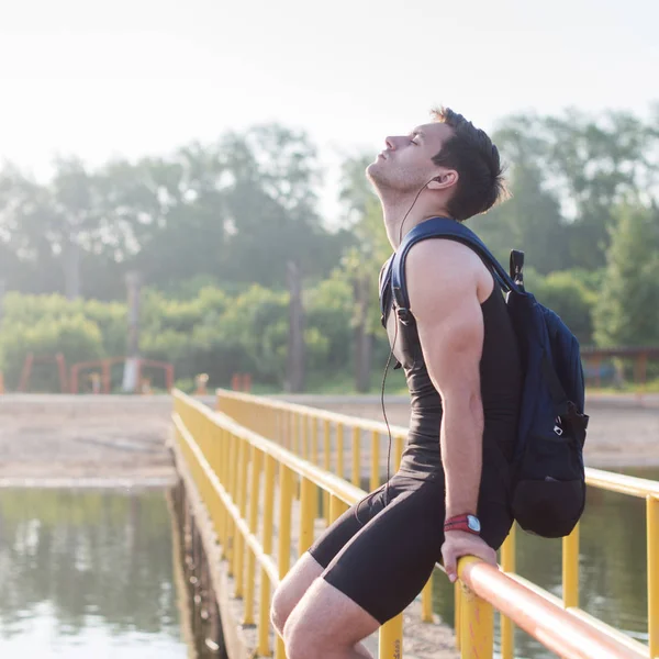 Jeune homme coureur se reposant après la séance d'entraînement le matin ensoleillé — Photo