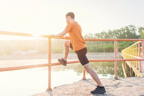 Hombre de fitness estirando los músculos de sus piernas al aire libre . —  Fotos de Stock