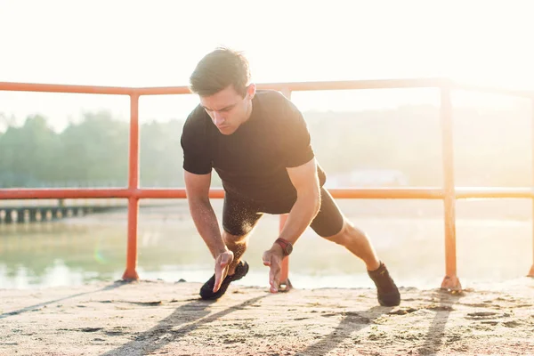 Fitnessmann macht klatschende Liegestütze und trainiert intensiv im Freien. — Stockfoto