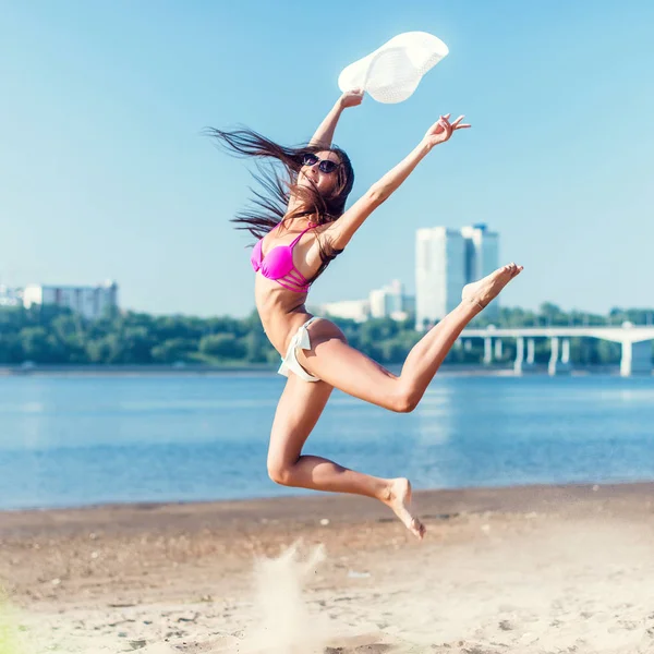 Vacker ung kvinna hoppa på stranden. — Stockfoto