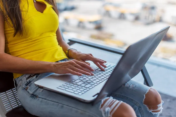 公共の場所で屋内でキーボードを入力する膝の上のラップトップを保持の若い女性の画像をトリミング — ストック写真