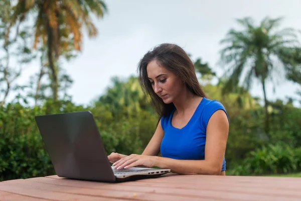 Glad flicka titta online video på bärbar dator sitter i parken — Stockfoto