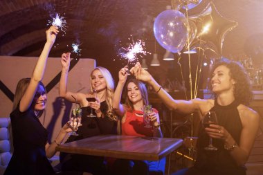 Havai fişek maytap alkollü kokteyller restoranda masa etrafında oturup içki ile eğleniyor doğum günü partisi zevk kadın arkadaş grubu