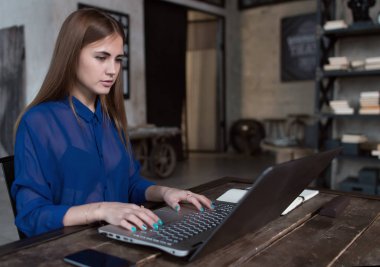 Öğrenci sınıfları trendy kafede masada oturan onun laptop internet sörf için hazırlanıyor