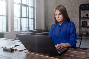 Genç ve güzel beyaz serbest meslek karanlık çatı dairesinde bir blog yazma